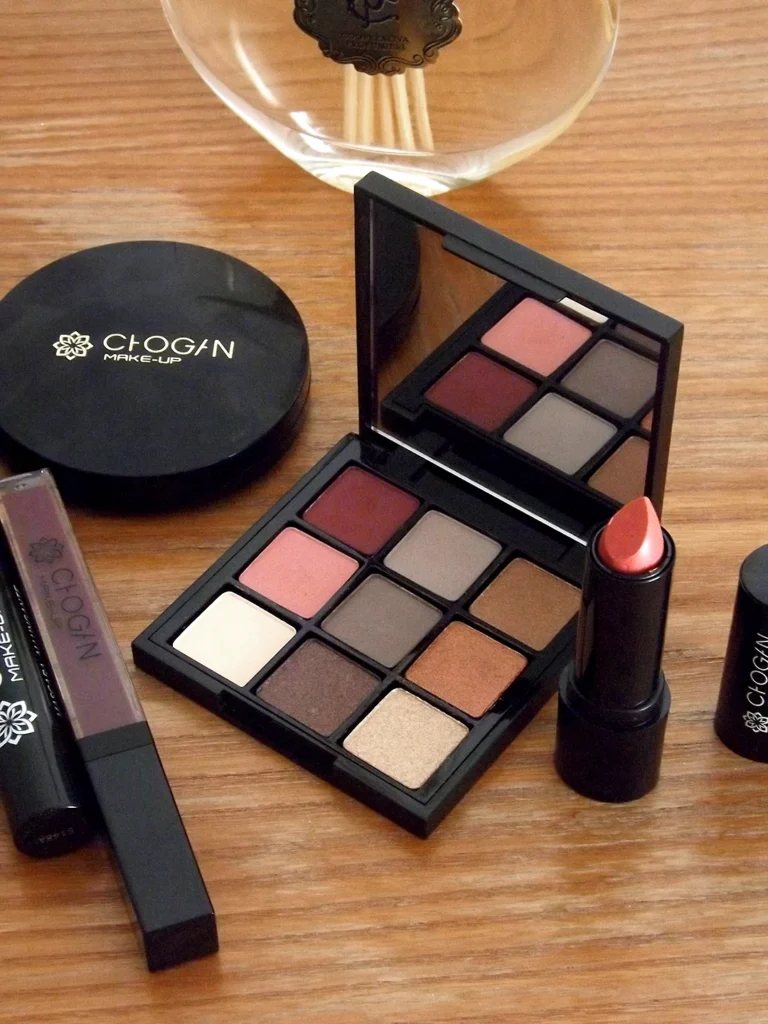 Divers produits de maquillage Chogan de la gamme Moni Amori (anciennement Chogan Make-Up), posés sur une belle commode en bois.