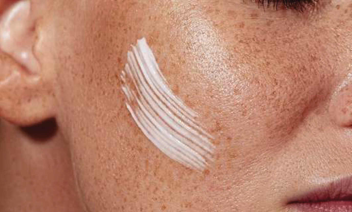 Gros plan d'une trace de crème hydratante sur une joue